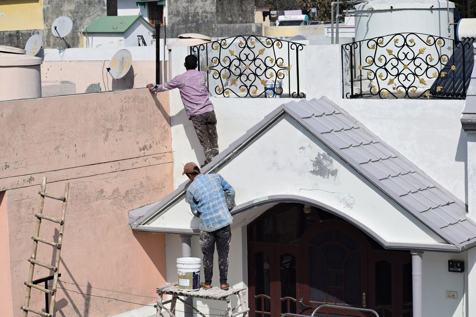 Exterior house painting contractor on a ladder